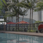 a pool with palm trees and umbrellas